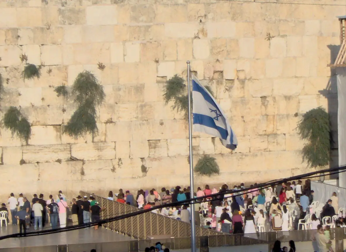 The Israeli flag flying before the stones of the Kotel