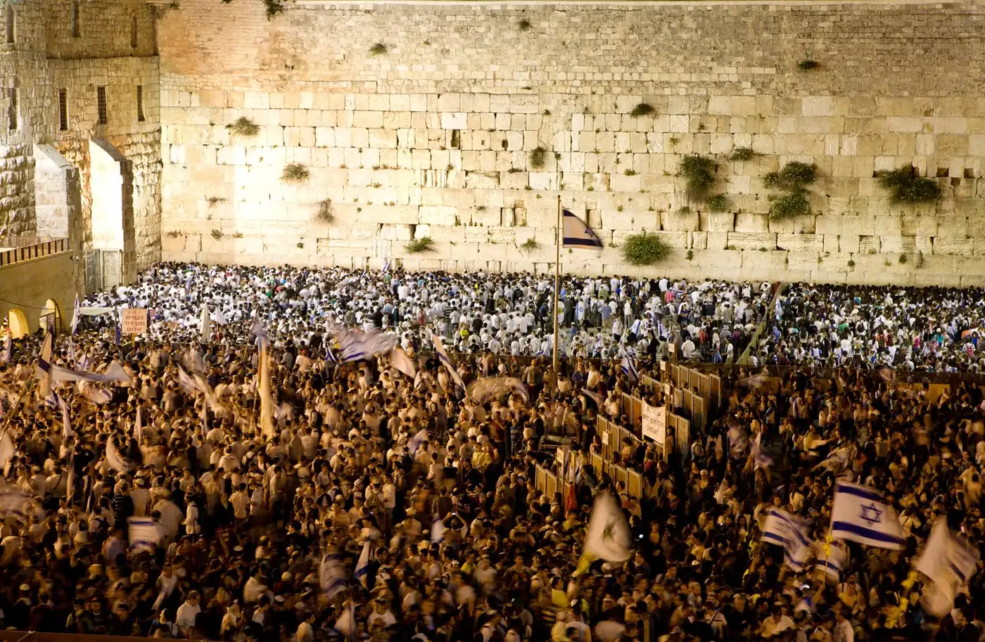 A vast crowd waving Israeli flags in the Kotel plaza